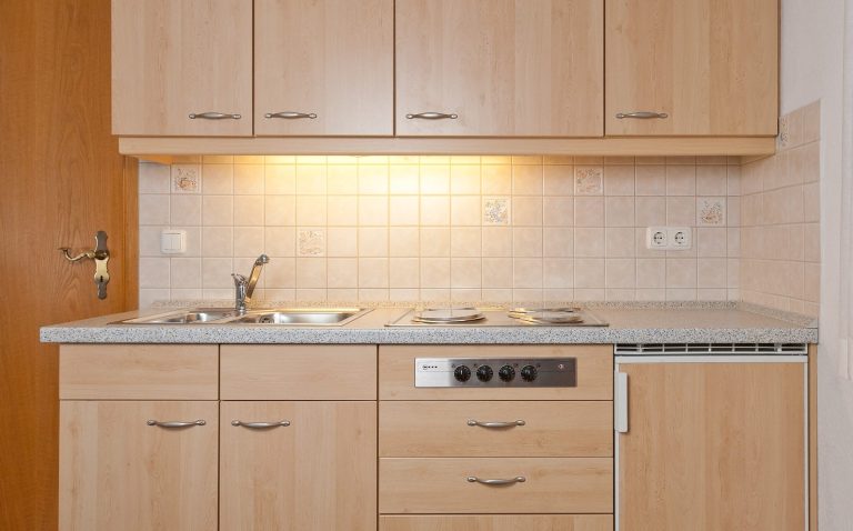 Moderne Küche mit Herd, Spüle und Kühlschrank.